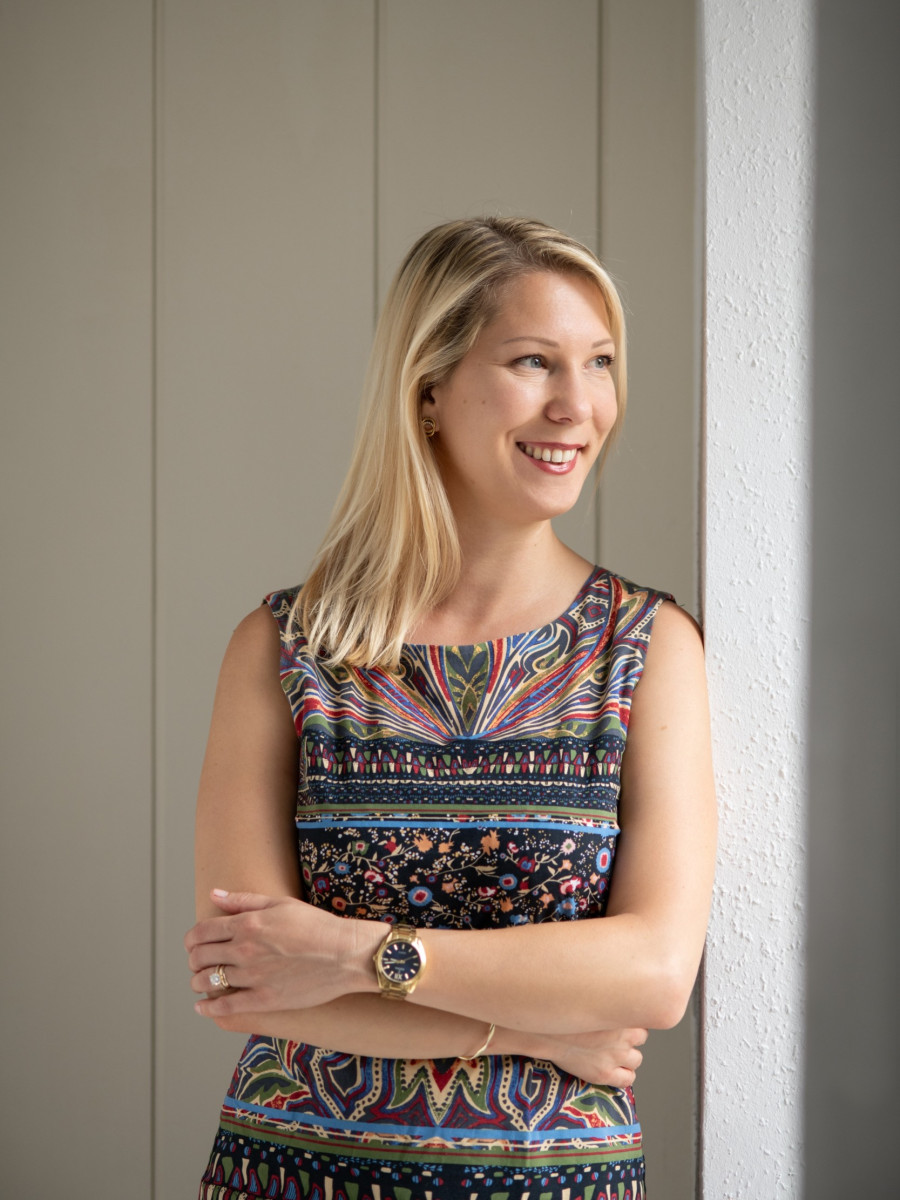 Psychotherapeutin Ines de Waal mit buntem Kleid vor einer beigen Wand